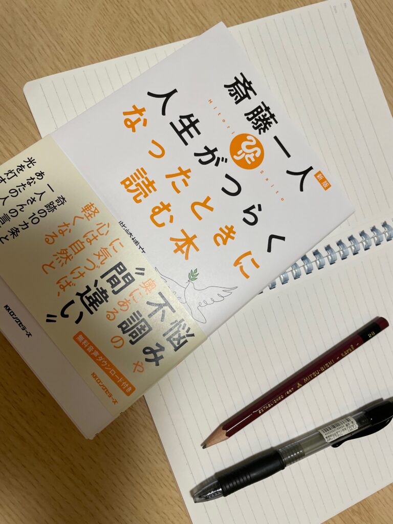 『<新版>斎藤ひとり 人生がつらくなったときに読む本』柴田博文 著 の表紙
ノートにメモをしながら。