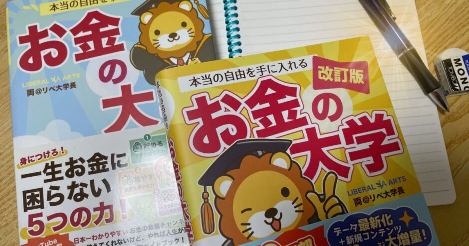 机の上にノートを広げ、その上に本とペンが置かれている写真